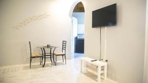 a dining room with a table and a tv on a wall at Ocean View Terrace in Montego Bay