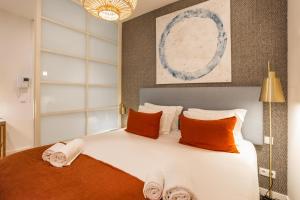 - une chambre avec un grand lit blanc et des oreillers orange dans l'établissement Chic Tailor Made Flat in Chiado, à Lisbonne