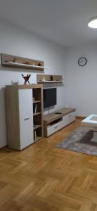 ein Wohnzimmer mit einem Kühlschrank und einem TV in der Unterkunft Apartman Davidović 31 in Valjevo