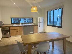 Una cocina con una mesa y sillas de madera. en La Escondida Salta 4, en Salta