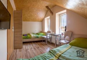 a bedroom with a bed and a desk and a table at Pokoje FreeDoor in Ługniany