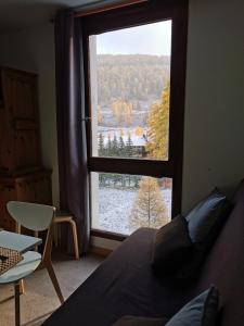 ein Schlafzimmer mit einem großen Fenster mit Blick auf einen Schnee in der Unterkunft Grand studio 4 à 6 personnes, au pied des pistes in Vars