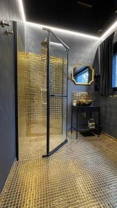La salle de bains est pourvue d'une douche avec une porte en verre. dans l'établissement Rezydencja Niva, à Warka