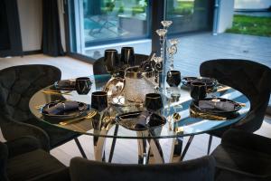 - une table en verre avec des assiettes et des ustensiles dans l'établissement Rezydencja Niva, à Warka