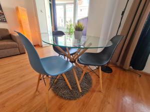 einen Glastisch und zwei Stühle im Wohnzimmer in der Unterkunft MIKA Square in Skopje