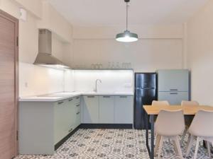 a kitchen with a table and a black refrigerator at KaSta Family Apartments in Nikiti