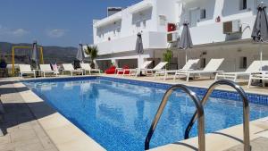 a hotel with a swimming pool in front of a building at Golden View Studios in Lindos