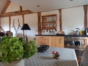 una cocina con una mesa con un bol de fruta. en The Barn at Titley, en Kington
