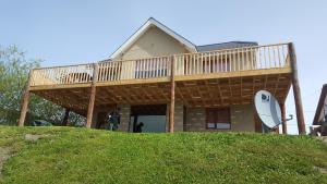 uma casa com um deque no topo de uma colina em Casa Franca em El Calafate