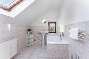 Un baño blanco con lavabo y bañera. en Penzion Polubný, en Kořenov 60 fotos más