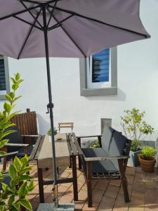 a wooden table with an umbrella on a patio at Apartement “Heckeresje“ in Pfungstadt