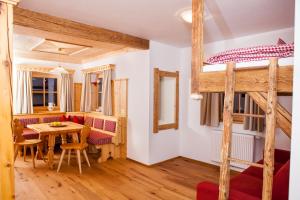 ein Schlafzimmer mit einem Etagenbett und einem Tisch sowie ein Esszimmer in der Unterkunft Bifeis Hütte in Altenmarkt im Pongau