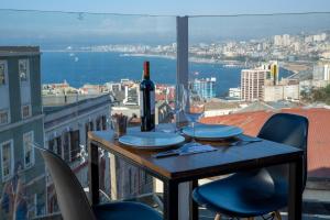a table with a bottle of wine and two glasses at BO Hotel & Terraza in Valparaíso