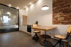 a kitchen with a wooden table and a brick wall at Saargemünder 128 in Saarbrücken +2 photos
