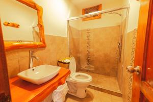 a bathroom with a sink and a toilet and a shower at Los Ponchos Inn Apartotel in Otavalo