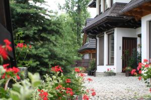 una casa con flores rojas delante de ella en Apartamenty Centrum Zakopane, en Zakopane