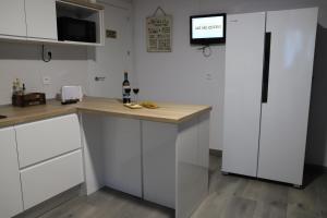 a kitchen with white cabinets and a counter with a tv at AKI ME QUEDO in Ledaña