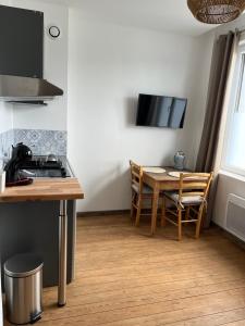 - une cuisine et une salle à manger avec une table et une cuisinière dans l'établissement Appartement 2 personnes : LES CANAUX, à Amiens