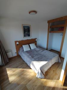 - une chambre avec un lit et du parquet dans l'établissement Appartement Le Sorbier à Chamrousse 3 pièces 6 personnes aux pieds des pistes, à Chamrousse