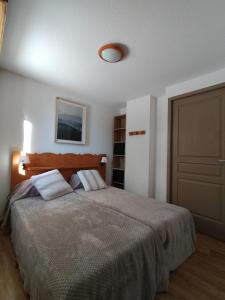 - une chambre avec un grand lit et un placard dans l'établissement Appartement Le Sorbier à Chamrousse 3 pièces 6 personnes aux pieds des pistes, à Chamrousse