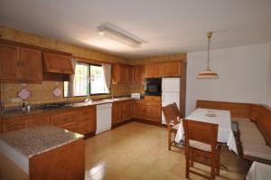 a kitchen with wooden cabinets and a table with chairs at Houm Villa Son Rigo in Playa de Palma