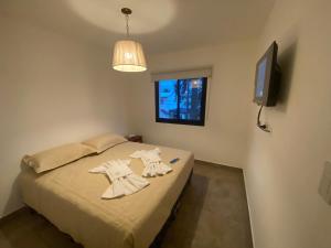 een slaapkamer met een bed met twee jurken erop bij La Escondida Salta 11 in Salta