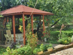 a wooden gazebo with a table and chairs in a garden at Broj jedan Delux in Soko Banja