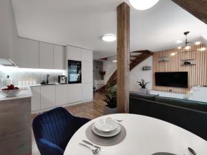 una cucina e un soggiorno con tavolo bianco e sedie blu di Old Town Museum Apartment a Liberec