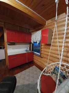 a kitchen with red cabinets and a swing in a room at Miego klinika 2 -POILSIUI be triukšmo visą parą in Kelmė