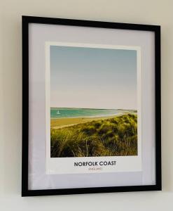 a framed picture of a north coast beach at Charming, cosy waterside retreat in Gimingham, North Norfolk in Gimingham
