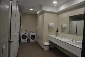 a bathroom with two washing machines and a washer and dryer at Albergue Credencial in Sarria