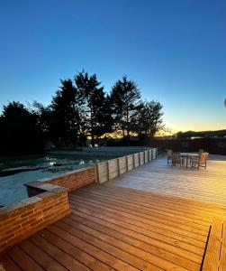 a wooden deck with a table and chairs on it at Charming, cosy waterside retreat in Gimingham, North Norfolk in Gimingham +14 photos