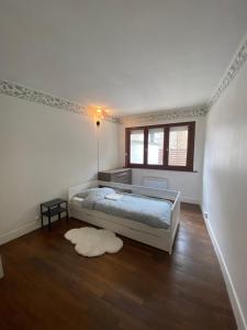 um quarto branco com uma cama e uma janela em Vesoul appartement atypique centre ville. em Vesoul