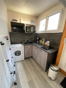 uma pequena cozinha com uma máquina de lavar roupa e uma máquina de lavar roupa em Vesoul appartement atypique centre ville. em Vesoul
