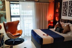 een slaapkamer met een bed, een stoel en een raam bij The Royal 213 - Downtown República - Centro - SP in Sao Paulo +75 foto's