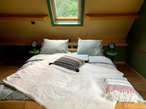 a large bed in a bedroom with two pillows on it at Oeroeboeroe in Roderesch