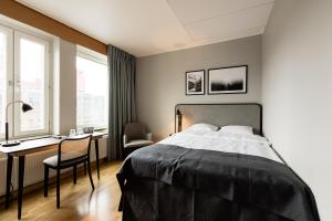 a bedroom with a bed and a desk and a chair at Clarion Collection Hotel Etage in Västerås
