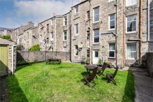 a yard with a table and chairs in front of a building at Aberdeen haven in Aberdeen city center in Aberdeen