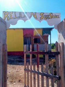 a wooden fence in front of a building with a sign at Relax N Sunshine 