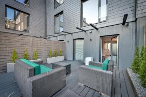 a patio with two wicker chairs and a table at Jacuzzi Cinema loft in Kaunas