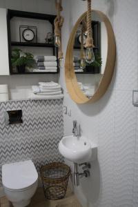 a bathroom with a toilet and a sink and a mirror at Apartamenty dla par Stara Szkoła in Weremowice +56 photos