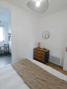 a bedroom with a bed and a dresser and a lamp at LA BERGE in Amiens