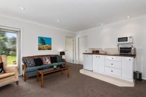 a living room with a couch and a microwave at Sunny on Sunlea - Mangawhai Village Holiday Unit in Mangawhai