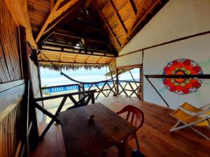 a table and chairs in a room with a view of the ocean at Hostal Mirada al Mar in Las Tunas