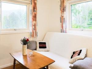 uma sala de estar com um sofá branco e uma mesa de madeira em 3 person holiday home in HEN N em Henån