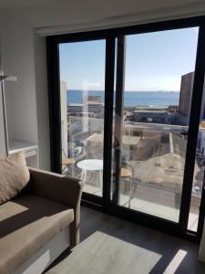 a living room with a couch and a view of the ocean at The Hub Gibraltar Sacha studio in Gibraltar