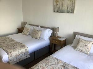 a room with two beds and a side table at Harbour View in Wick