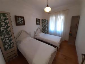two beds in a small room with a window at Acogedor piso en pleno centro de Zaragoza in Zaragoza