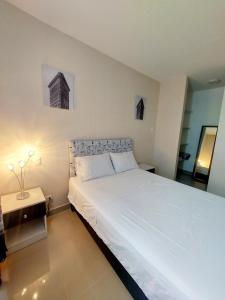 - une chambre avec un grand lit blanc dans l'établissement Dpto 3 hab en Piura - GARDEN 360~, à Piura