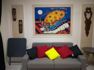 a couch in a living room with a painting on the wall at Lindo Apartamento na Praia do Futuro in Fortaleza